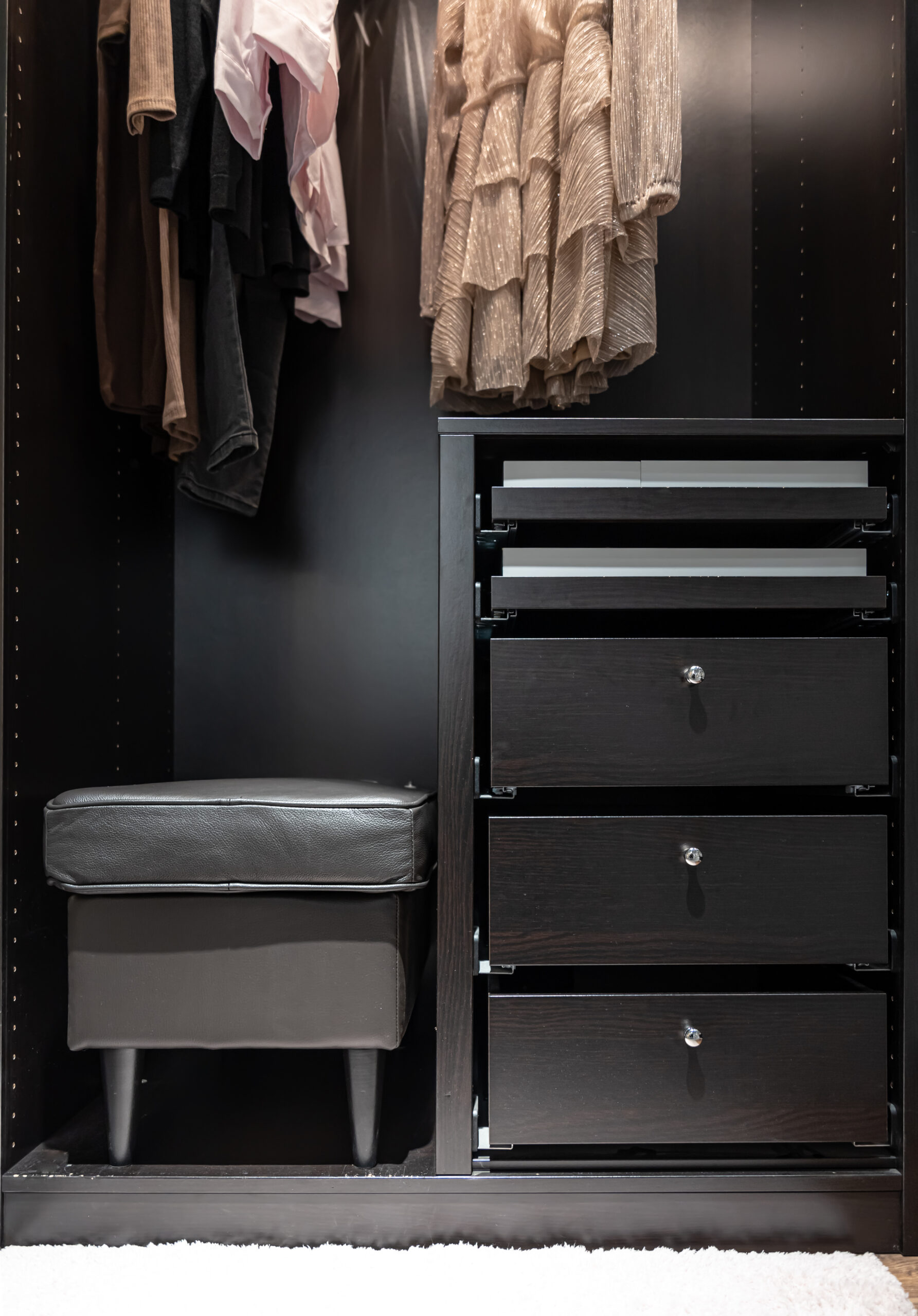 Black wardrobe, locker and pouf, inside view, wardrobe interior.